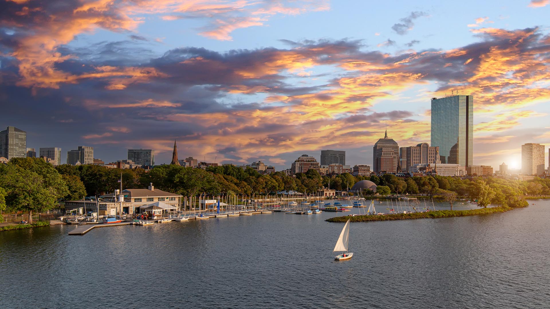 Landscape panoramic view of downtown Boston at sunset next to the Charles River.